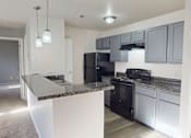 Thumbnail 1 of 30 - A kitchen with black appliances and a granite countertop.