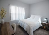 Thumbnail 7 of 39 - a bedroom with a bed and a desk and a window