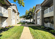 Thumbnail 33 of 37 - A sunny day at a residential apartment complex with a clear blue sky.