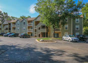 Thumbnail 9 of 10 - a parking lot in front of an apartment complex
