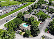 Thumbnail 27 of 29 - A bird's eye view of a parking lot with cars and a building with a pool.