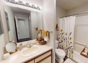Thumbnail 9 of 29 - A bathroom with a white sink and a white toilet.