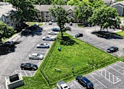 Thumbnail 20 of 29 - A parking lot with cars and a green lawn.