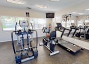 Thumbnail 13 of 29 - A gym with a row of treadmilers and elliptical machines.