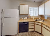 Thumbnail 6 of 29 - A white refrigerator stands in a kitchen with wooden cabinets and a black dishwasher.