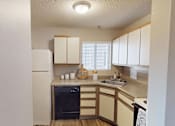 Thumbnail 5 of 29 - A kitchen with a white refrigerator, wooden cabinets, and a black oven.