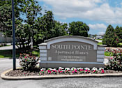 Thumbnail 22 of 29 - A sign for Southpointe Apartment Homes is surrounded by flowers and greenery.