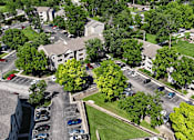 Thumbnail 28 of 29 - A parking lot with cars and apartment buildings in the background.