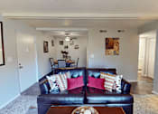 Thumbnail 10 of 36 - A living room with a couch and a coffee table.