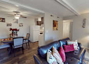 Thumbnail 11 of 36 - A living room with a black leather couch and a dining table with chairs.