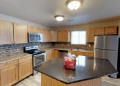 Thumbnail 2 of 10 - apartment kitchen with a granite counter top and wooden cabinets