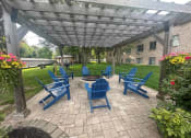 Thumbnail 15 of 20 - a patio with blue chairs and a fire pit