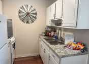 Thumbnail 1 of 20 - a kitchen with a sink and a refrigerator