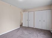 Thumbnail 11 of 20 - a bedroom with two closets and a carpeted floor