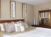 Thumbnail 8 of 31 - a bedroom with a large bed with pillows and a mirror on the wall