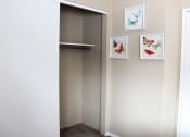 Thumbnail 14 of 31 - a closet with a sliding door and three pictures of butterflies on the wall