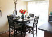 Thumbnail 7 of 31 - a dining room table with a vase of flowers on top of it