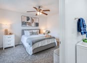 Thumbnail 4 of 27 - A bedroom with a bed, nightstand, and a ceiling fan.