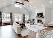 Thumbnail 6 of 27 - A spacious living room with a fireplace and a ceiling fan.