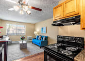 Thumbnail 5 of 35 - A living room with a blue couch and a black stove.
