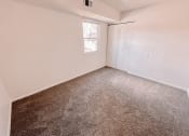 Thumbnail 12 of 13 - an empty bedroom with carpeting and a door to a closet