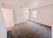 Thumbnail 10 of 13 - an empty living room with carpet and a window