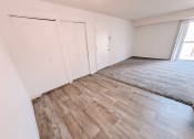 Thumbnail 7 of 13 - the living room and bedroom of an apartment with wood flooring