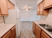 Thumbnail 4 of 13 - a kitchen with wooden style cabinets and a refrigerator
