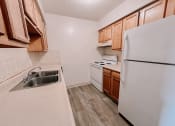 Thumbnail 3 of 13 - a kitchen with white appliances and wooden cabinets