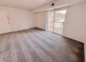 Thumbnail 6 of 13 - an empty living room with a sliding glass door to a balcony