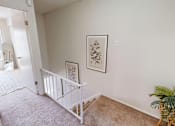 Thumbnail 7 of 33 - A baby's crib sits in a corner of a room with a framed picture on the wall above it.