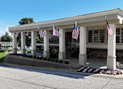 Thumbnail 27 of 33 - A building with columns and flags hanging from the roof.