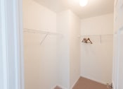 Thumbnail 16 of 33 - a closet with a white wall and a hanging rack on the wall