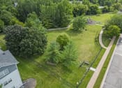 Thumbnail 22 of 33 - an aerial view of a dog park with trees and a sidewalk