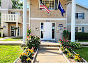 Thumbnail 26 of 28 - The front of a building with a white door and a sign that says