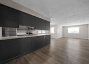 Thumbnail 7 of 33 - the view of a kitchen and living room with black cabinets