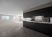 Thumbnail 13 of 33 - an empty living room with a kitchen with black cabinets