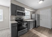 Thumbnail 8 of 33 - a kitchen with black cabinets and stainless steel appliances