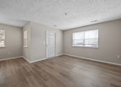 Thumbnail 15 of 33 - an empty living room with a white door and a window