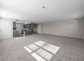 Thumbnail 12 of 33 - an empty living room with a kitchen in the background