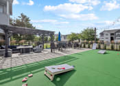 Thumbnail 26 of 33 - the clubhouse patio with tables and chairs and a putting green