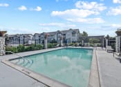 Thumbnail 24 of 33 - a swimming pool with apartment buildings in the background