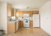 Thumbnail 31 of 33 - a kitchen with white appliances and wooden cabinets