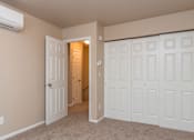 Thumbnail 7 of 16 - A room with a white door and a carpeted floor.