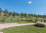Thumbnail 14 of 16 - A pathway with a fence and a large rock in the foreground.