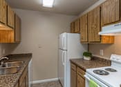 Thumbnail 1 of 16 - A kitchen with a white refrigerator and stove top oven.
