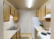 Thumbnail 3 of 16 - A kitchen with wooden cabinets and a white refrigerator.