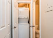 Thumbnail 5 of 16 - A white door opens to a small bathroom with a toilet and a white cabinet.