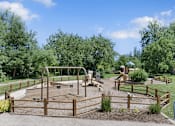 Thumbnail 10 of 16 - A playground with a swing set and a slide.