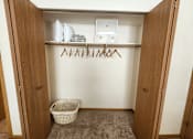 Thumbnail 11 of 28 - A laundry room with a basket and clothes hangers.